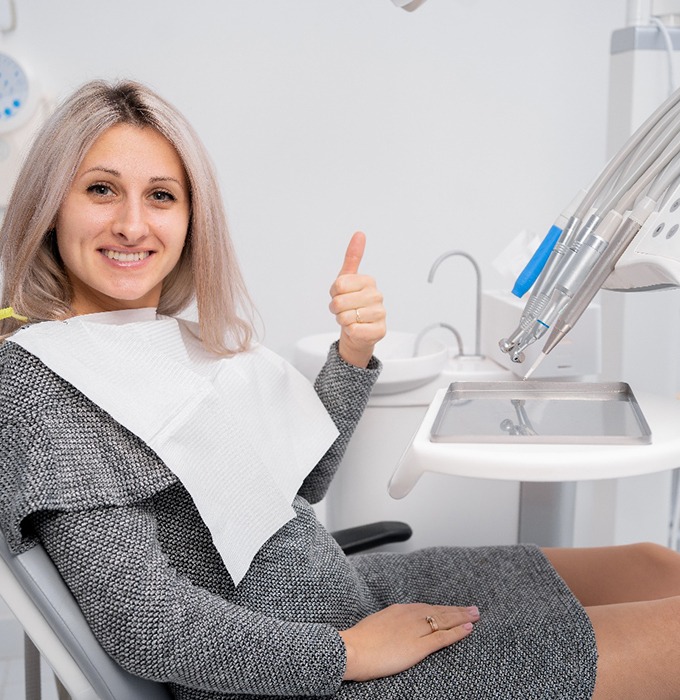 Happy dental patient making thumbs-up gesture