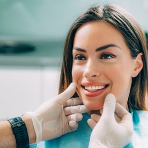 Chelsea dentist using dental mirror to examine teeth