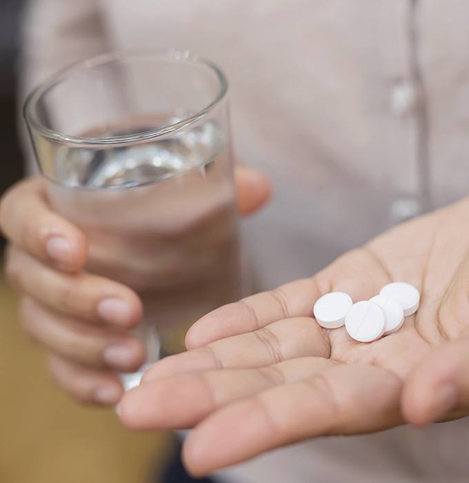 Hand holding antibiotic therapy pills