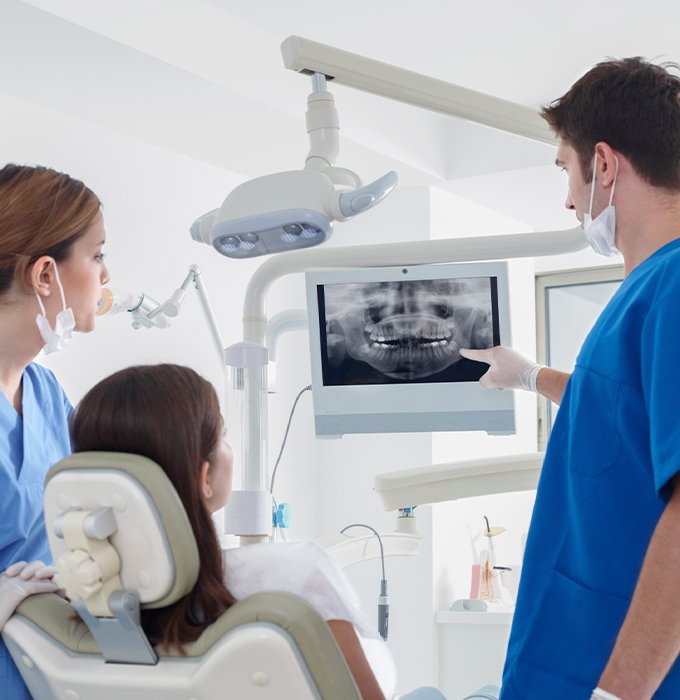 Dentist and dental patient looking at digital x-rays