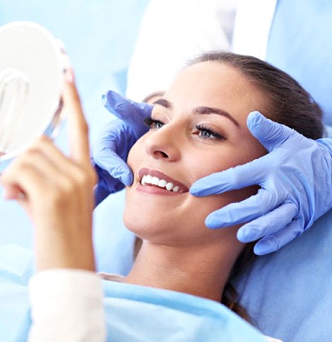 woman admiring her smile in the mirror