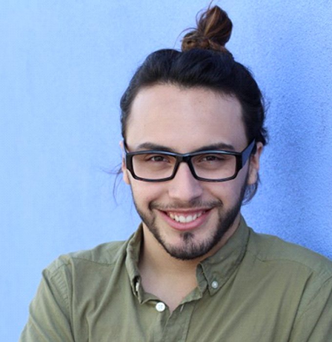 man smiling in front of a blue background