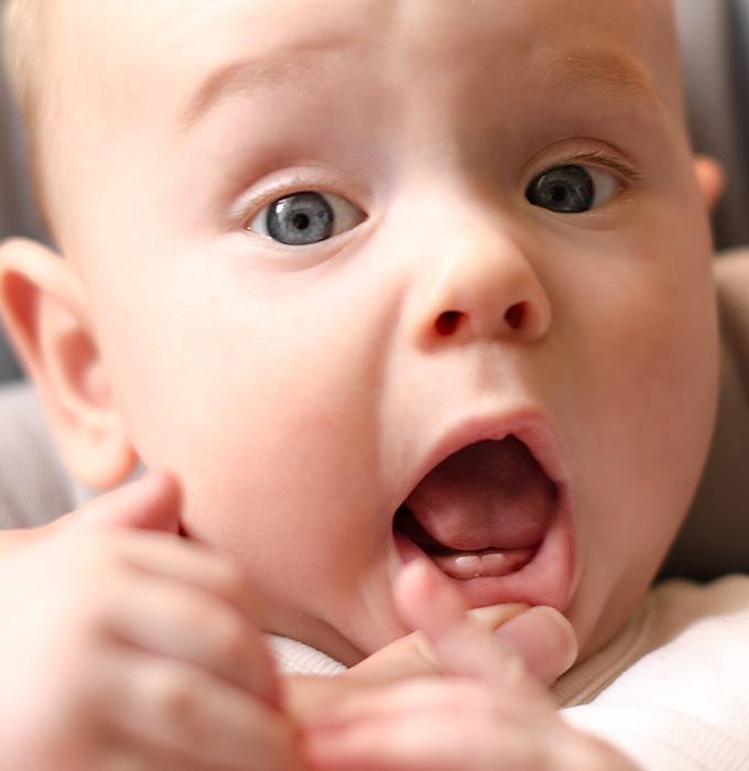 Dentist checking infant for lip and tongue tie