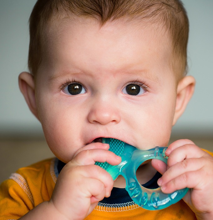 Child in need of pulp therapy chewing on teething ring