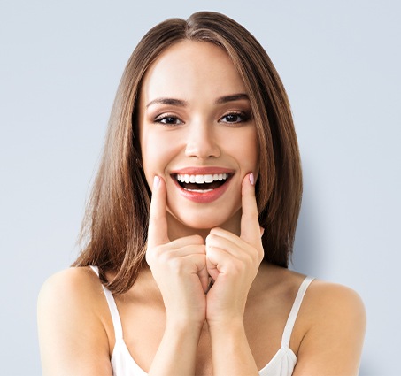 Woman pointing to smile after cosmetic dentistry