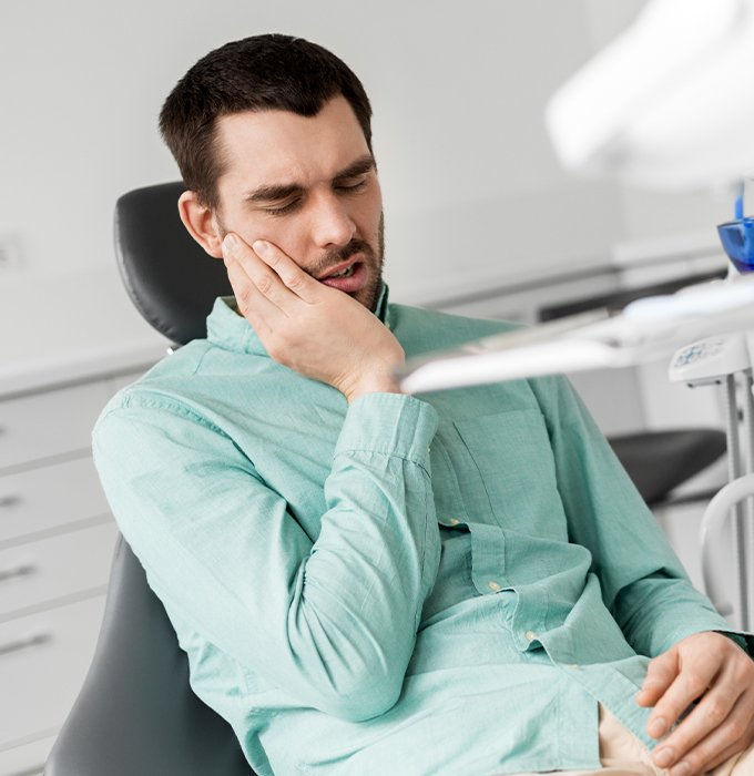Man holding jaw during emergency dentistry