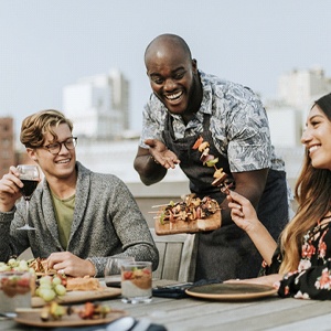 Friends eating outside smiling with dental implants in Lansing