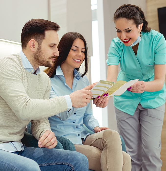 Dental team member showing patients dental insurance forms