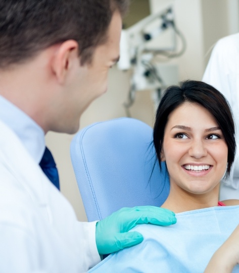 Woman in dental chair smiling at dentist