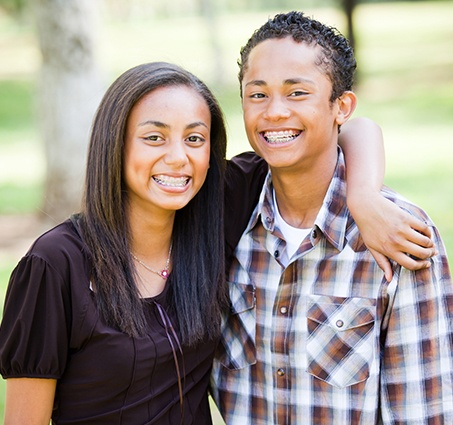 Two smiling teens with braces