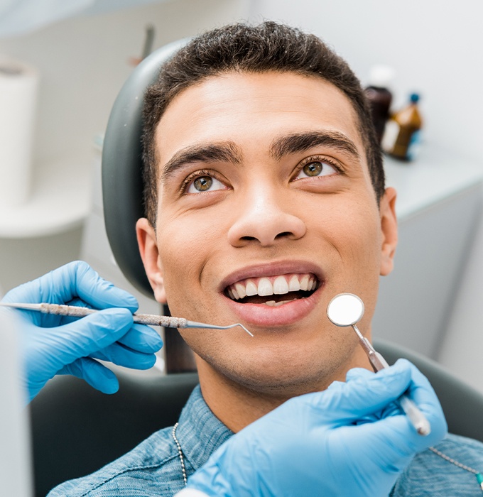 Young man receiving dental checkup and teeth cleaning
