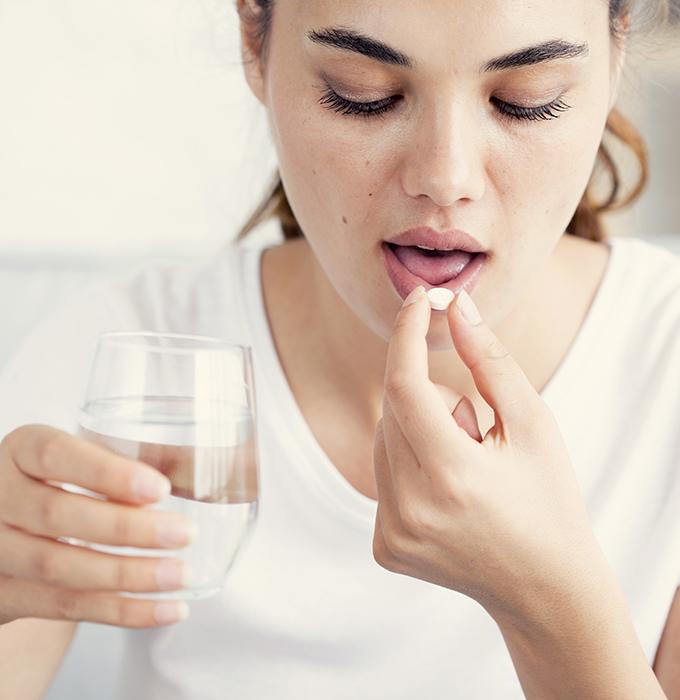 Woman taking oral conscious dental sedation pill