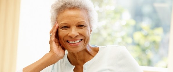 Woman smiling after dental implant tooth replacement