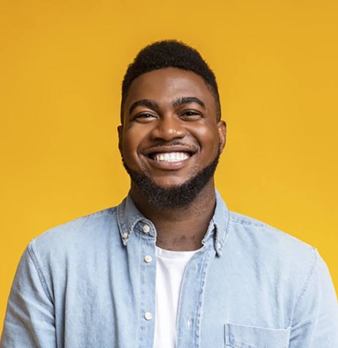 man smiling against a yellow background