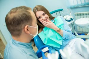 young woman talking to her cosmetic dentist in Lansing about teeth whitening 