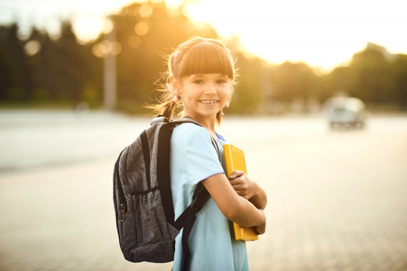 child happy to prevent dental emergencies in Lansing