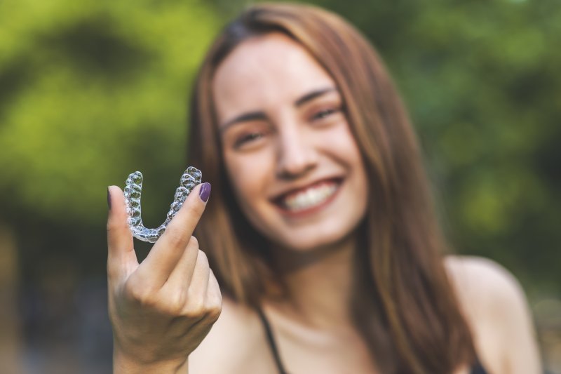 person holding clear aligner trays