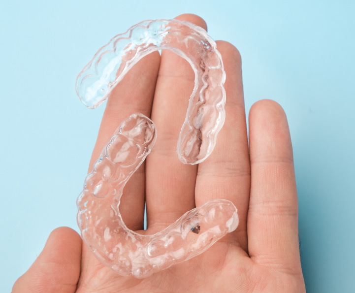 Hand holding clear aligners